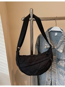 Black quilted crescent shoulder bag with adjustable strap and diamond stitching