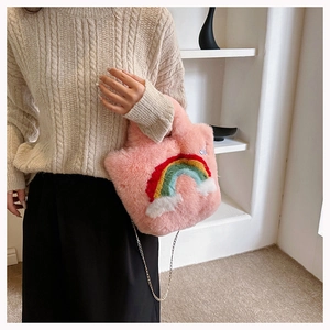 Detail of pink plush handbag with rainbow and cloud applique and thin metal chain strap