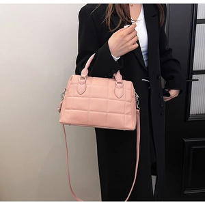 Close-up of pink quilted bowling handbag with silver hardware and adjustable strap