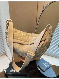 Quilted beige half-moon hobo bag with adjustable wide strap and puffer lattice texture