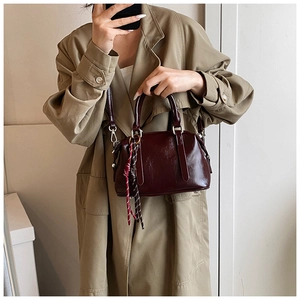 Sac à main vintage rouge foncé avec foulard en soie porté avec un long manteau kaki
