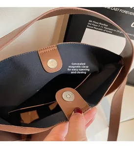Close-up of brown pebbled leather bag with hidden magnetic snap closure and black lining