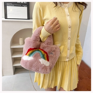 Detailed view of pink plush crossbody bag with rainbow cloud patch and bear embroidery