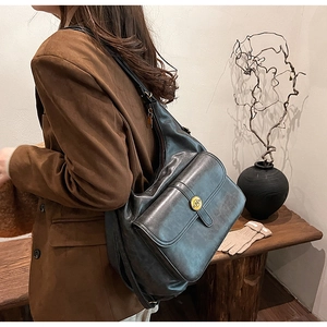 Dettaglio macro della borsa hobo in pelle invecchiata con fibbia dorata e lettera N