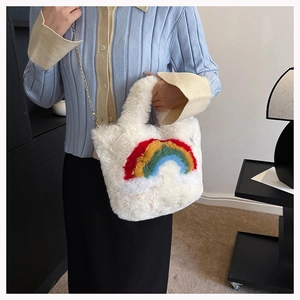 Detailed plush texture of white faux fur handbag with rainbow pattern and gold chain strap
