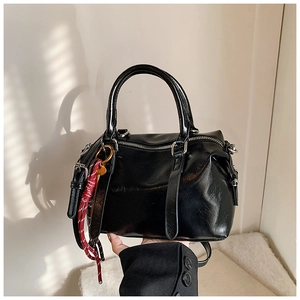 Détail du sac Boston noir brillant avec corde tissée tricolore et doubles poignées