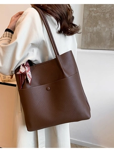 Large dark brown pebble leather bucket bag for women with a decorative silk scarf accessory