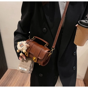 Détail d'un sac oreiller vintage marron foncé avec verrous en bronze et pendentif agneau
