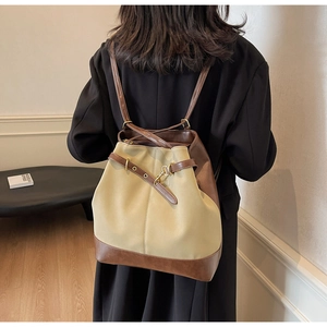Detail of khaki canvas and brown leather stitching with brass buckle on retro backpack