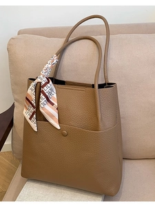 Brown lychee leather tote bag with decorative silk scarf on handle and front pocket