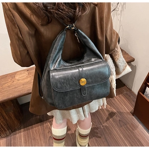Dettaglio della borsa vintage in pelle grigio scuro con finitura testurizzata e fibbia in oro