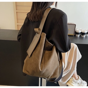 Detail of minimalist hobo bag in premium brown suede with leather shoulder strap