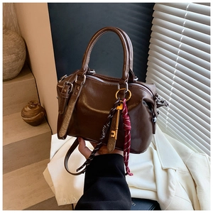 Vue détaillée d'un sac Boston vintage marron avec pendentif clé et cordon tressé
