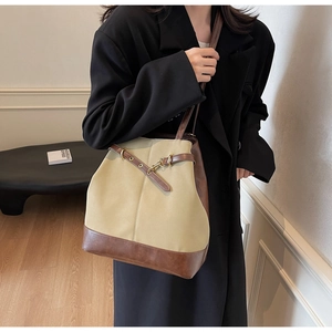 Close-up of khaki canvas and brown leather stitching on a large vintage tote bag