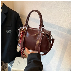 Vue détaillée du sac Boston bordeaux vintage avec pendentifs et finition brillante
