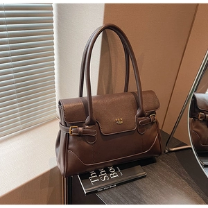 Close-up of coffee brown leather shoulder bag with gold buckle and embossed brand detail