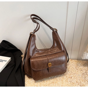 Dettaglio borsa hobo marrone vintage con fibbia dorata N e tasca frontale con patta moda