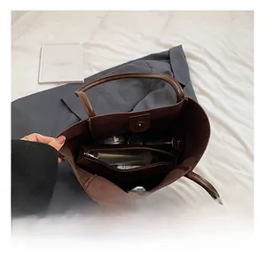 Spacious interior of dark brown leather tote bag with a matching zip pouch and inner lining