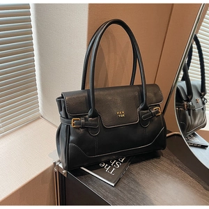 Close-up of black retro tote bag with golden PAN 'TOR logo and elegant leather straps