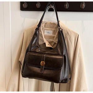 Dettaglio della borsa hobo in pelle lucida marrone scuro con tasca a patta e stemma in metallo