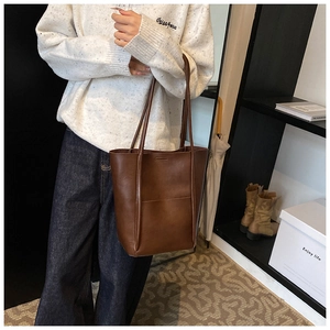 Brown vintage leather tote bag shown with casual knitwear and denim for a stylish look