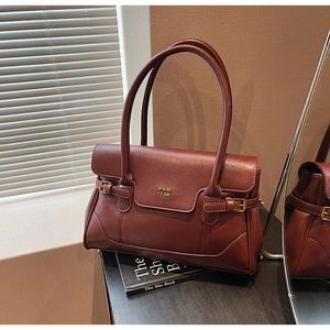 Close-up of burgundy leather shoulder bag featuring gold buckle and PAN'TOR logo
