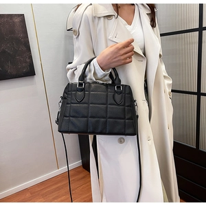 Detailed side view of black quilted leather tote bag with elegant silver-tone hardware