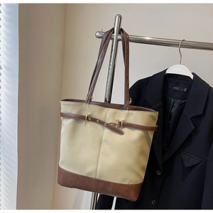 Detail of contrast tote bag with gold horsebit buckle and brown leather stitching