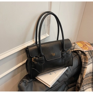 Detail of black faux leather tote with PAN TOR gold lettering and dual shoulder straps