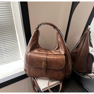 Dettaglio borsa hobo vintage in ecopelle marrone con tasca anteriore e fibbia in metallo