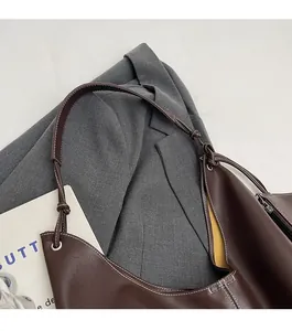 Détail du sac cabas marron foncé montrant les surpiqûres et la bandoulière nouée