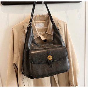 Dettaglio borsa hobo grigia vintage con texture in pelle opaca e fibbia in bronzo N