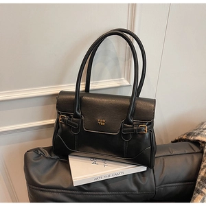Close-up of black leather tote bag with gold PAN TOR logo on white interior background