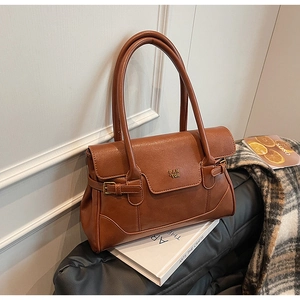 Detail of Fan Tor brown vintage leather shoulder bag with gold metal logo and flap