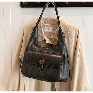 Dettaglio della borsa hobo grigio scuro vintage con tasca frontale e bottone in metallo