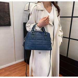 Detail of navy blue quilted Boston bag with silver hardware and adjustable strap