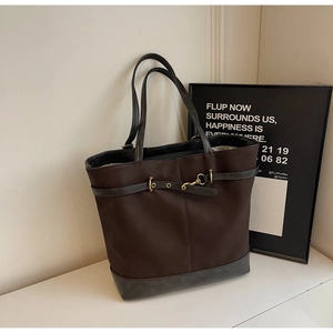 Detailed close-up of brown nylon tote bag with leather corners and gold horsebit buckle