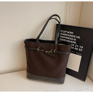 Detailed view of brown tote bag with premium leather trim and golden metal horsebit hardware