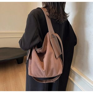 Close-up of brown suede hobo bag with leather shoulder strap showing premium texture