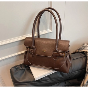 Detail view of premium dark brown leather tote bag with fine texture and gold logo