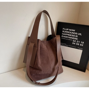 Detail of brown faux suede tote bag featuring mixed textures and side pocket