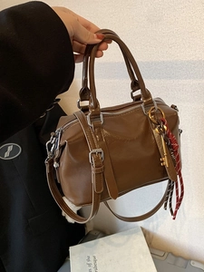 Sac Boston vintage marron avec poignées et un pendentif décoratif en forme de clé