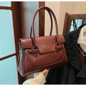 Detail view of burgundy leather tote with gold PAN 'TOR logo and adjustable straps
