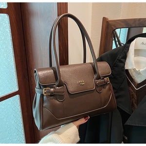Close-up of retro dark brown leather tote with PAN'TOR logo and refined metal side buckles