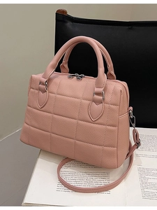 Pink quilted shell tote bag with dual handles and adjustable strap on magazine