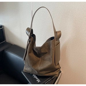 Detail view of large dark brown suede hobo bag showing soft matte texture and leather trim