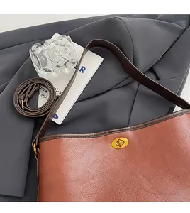 Details der braunen Vintage-Ledertasche mit goldenem Drehverschluss und zwei Riemen