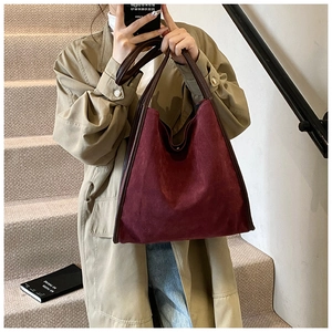 Detail der weinroten Shopper-Tasche aus mattem Leder mit braunen Trägern in Herbstszene