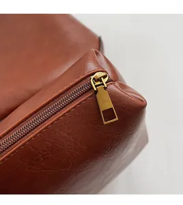 Details des glatten Bronze-Reißverschlusses und der Lederstruktur dieser braunen Tasche
