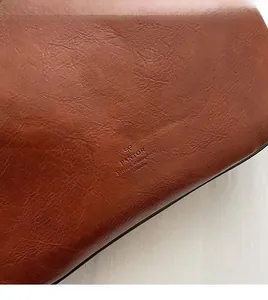 Nahaufnahme der braunen Kieselleder-Textur mit PANTOR-Logoprägung auf der Tasche